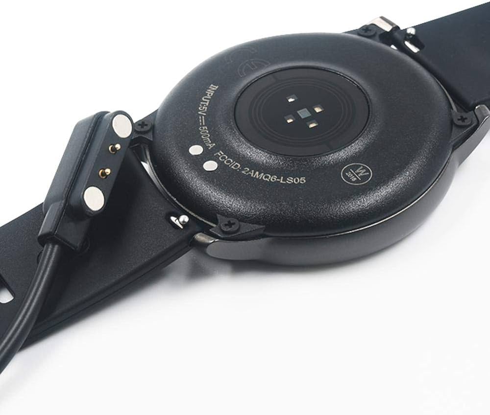 Image of a smart watch showing a magnetic charging cable. Two small dots on the back of the watch match to the two prongs on the charging cable. These are the dots that need to be cleaned.